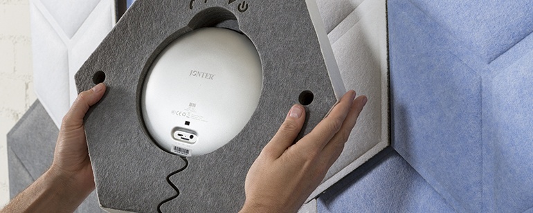 Person Installing a Hexagonal Sound Absorbing Panel on a Wall