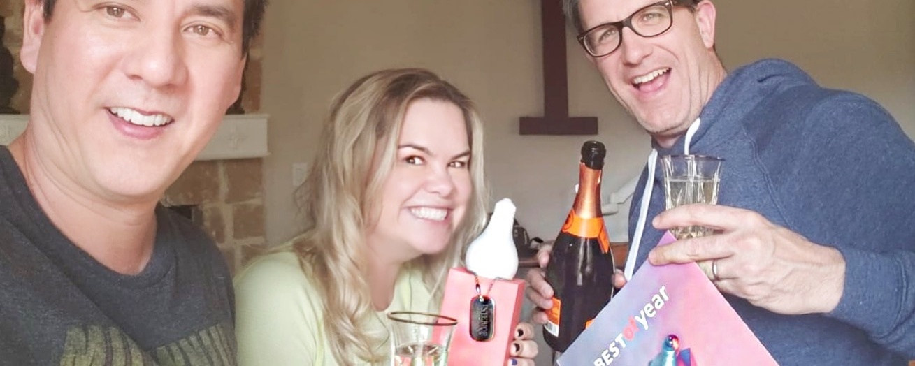 Three People Celebrating with Champagne and Smiling