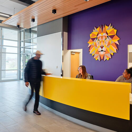 People Engage in Conversation in a Vibrant Modern Office Lobby with Artistic Decor