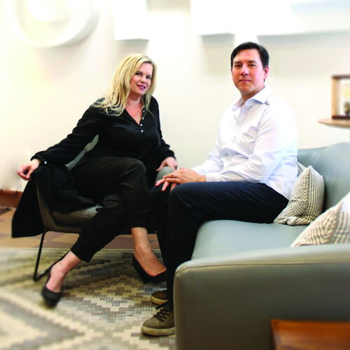 Two Professionals Sitting in a Modern Lounge Area During a Discussion