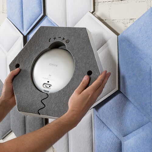 Person Installing a Hexagonal Sound Absorbing Panel on a Wall