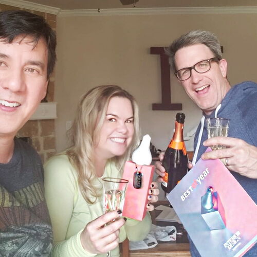 Three People Celebrating with Champagne and Smiling
